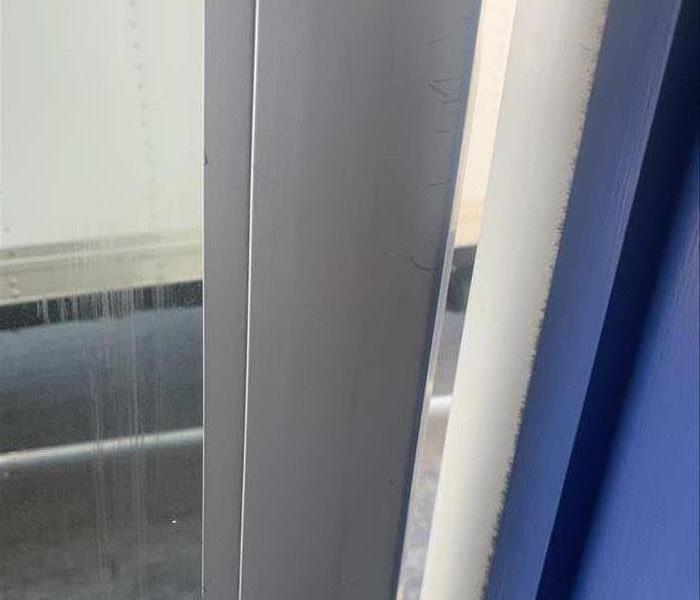 Metal framed door at an automotive shop after soot has been cleaned off of it