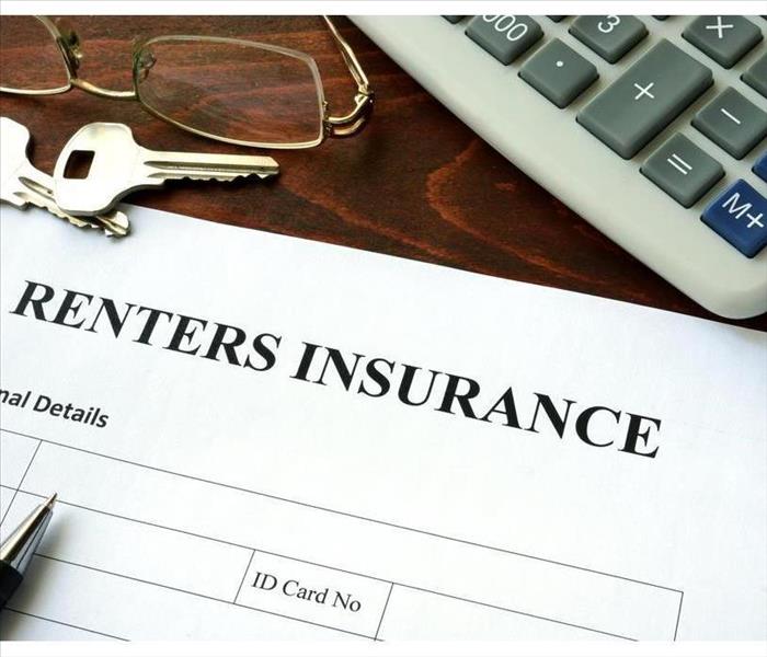 Renter insurance form on a table with a calculator and a pair of glasses