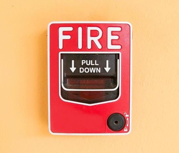 A red fire alarm on a wall.